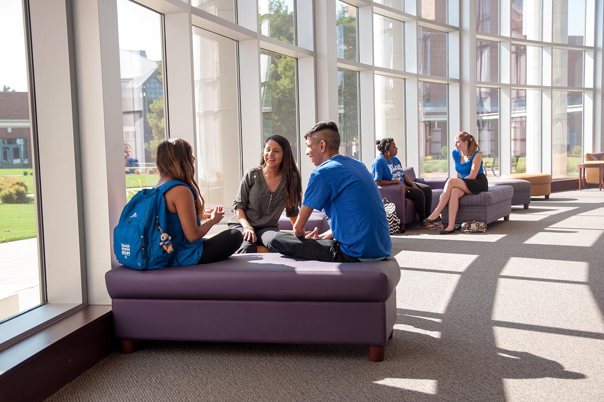 Students sit in the Plano Campus library and work collaboratively